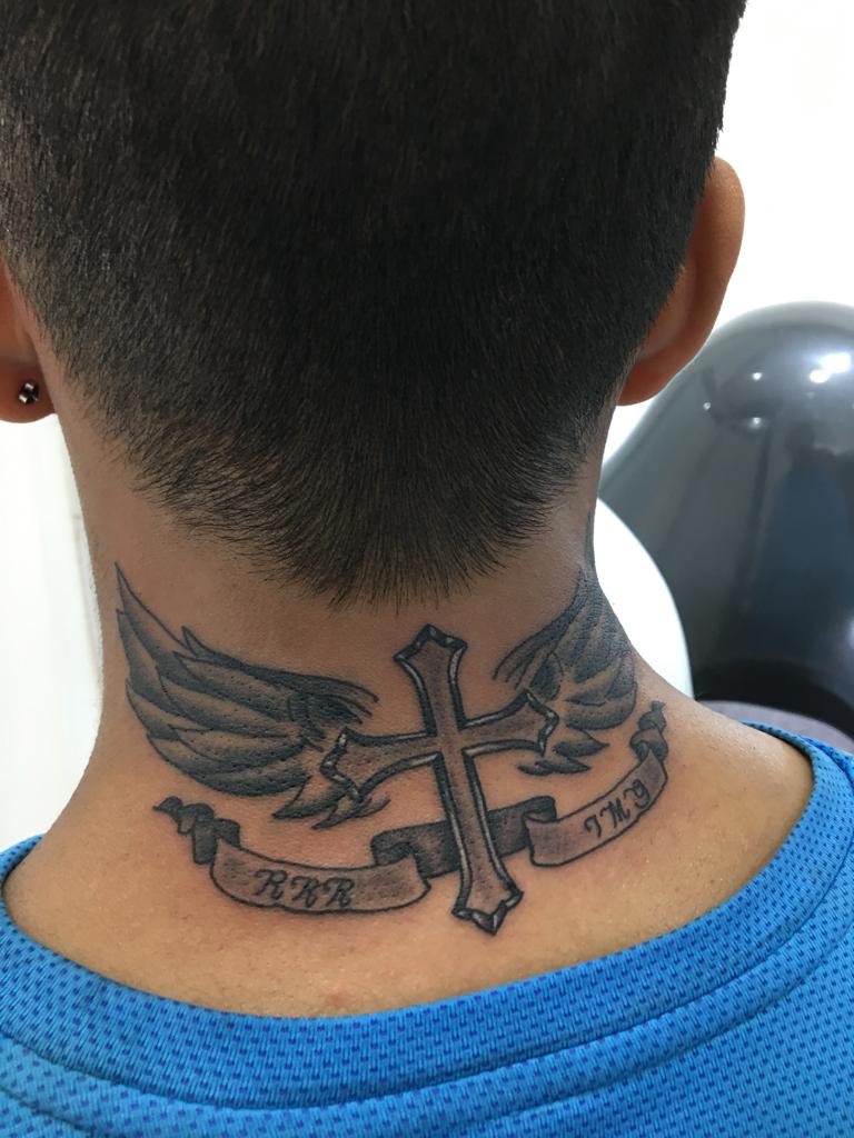Tatuaje de cruz alada en la nuca, trabajo real de Devil Twin Tattoo Studio