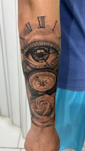 Tatuaje realista de ojo, reloj y rosa en antebrazo, trabajo real de Devil Twin Tattoo Studio